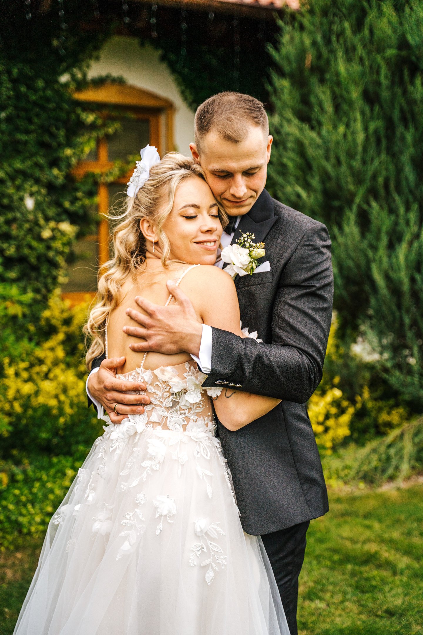 a bride and groom embracing each other in a garden