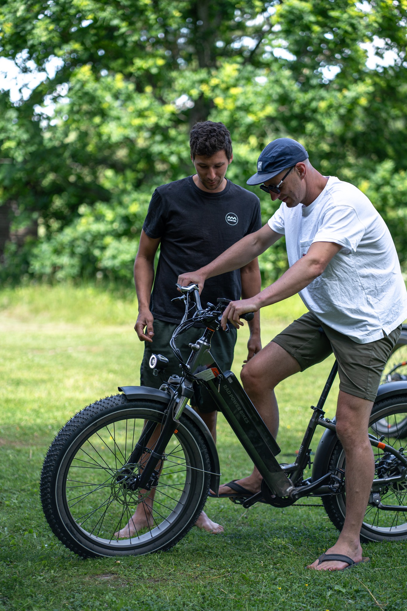 a man standing next to a man on a electric bike