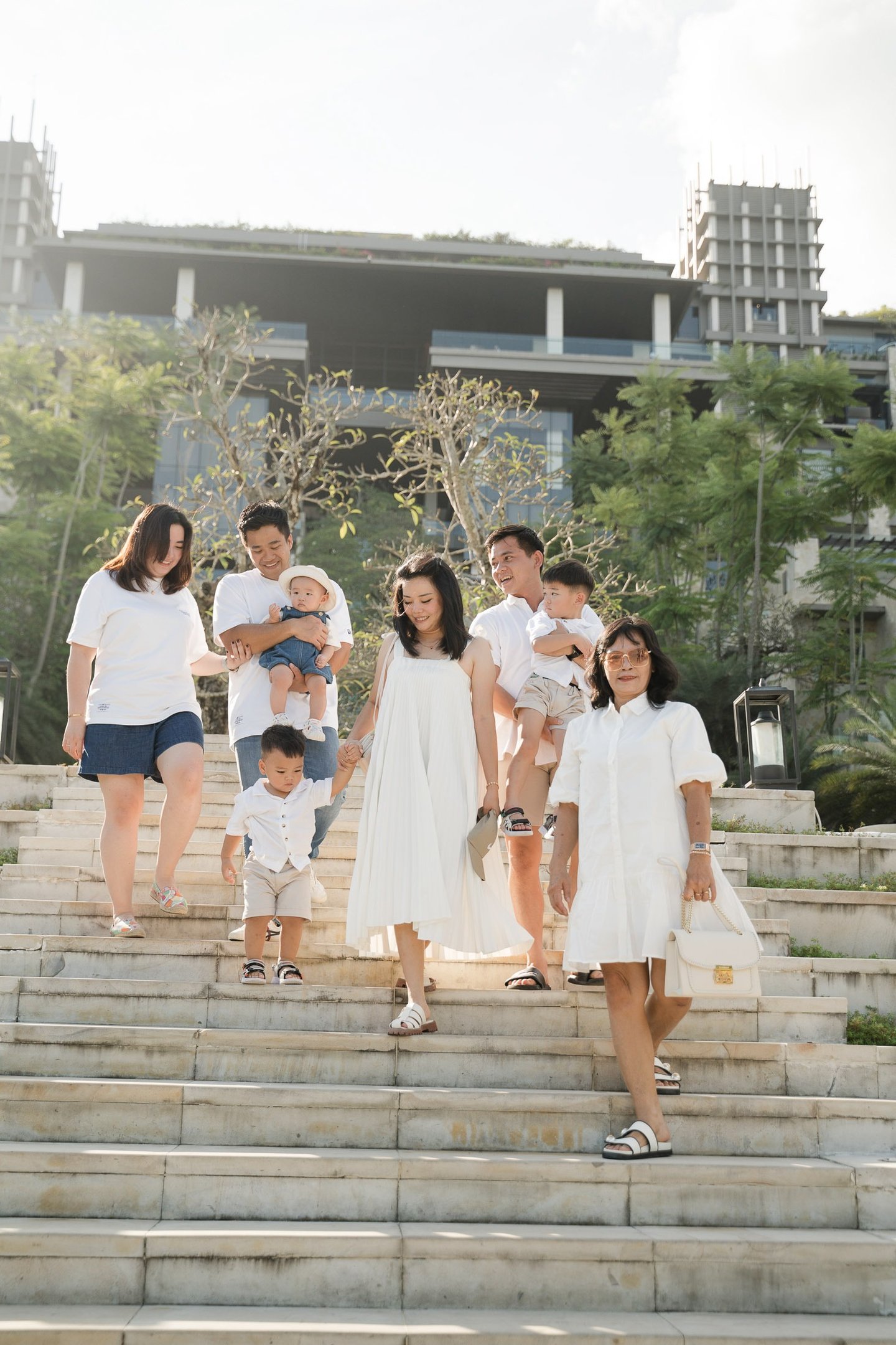 Large family walking down the iconic staircase at The Apurva Kempinski Nusa Dua Bali during a family photography session