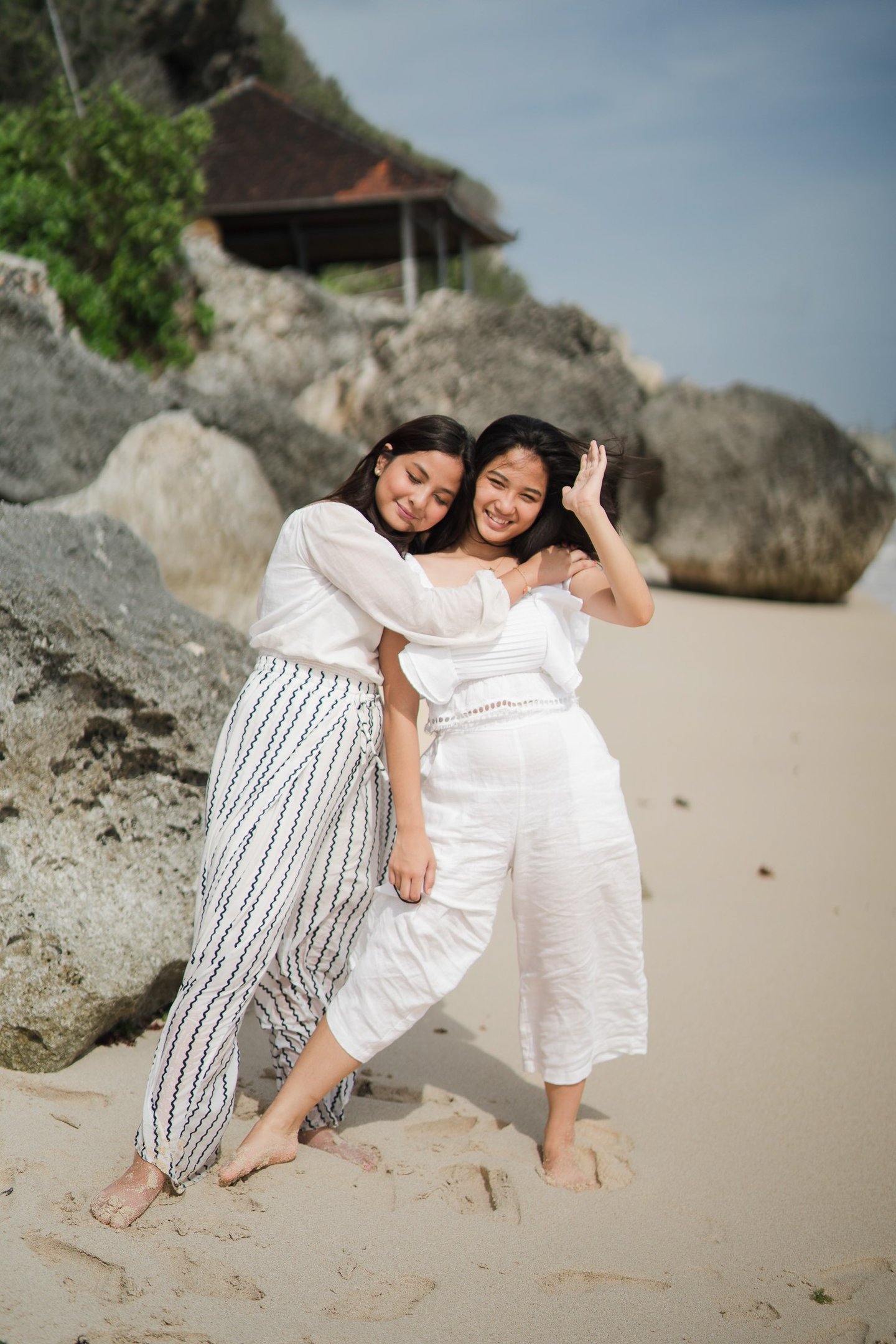 Two daughters embracing each other on the beach at Karma Kandara Bali  