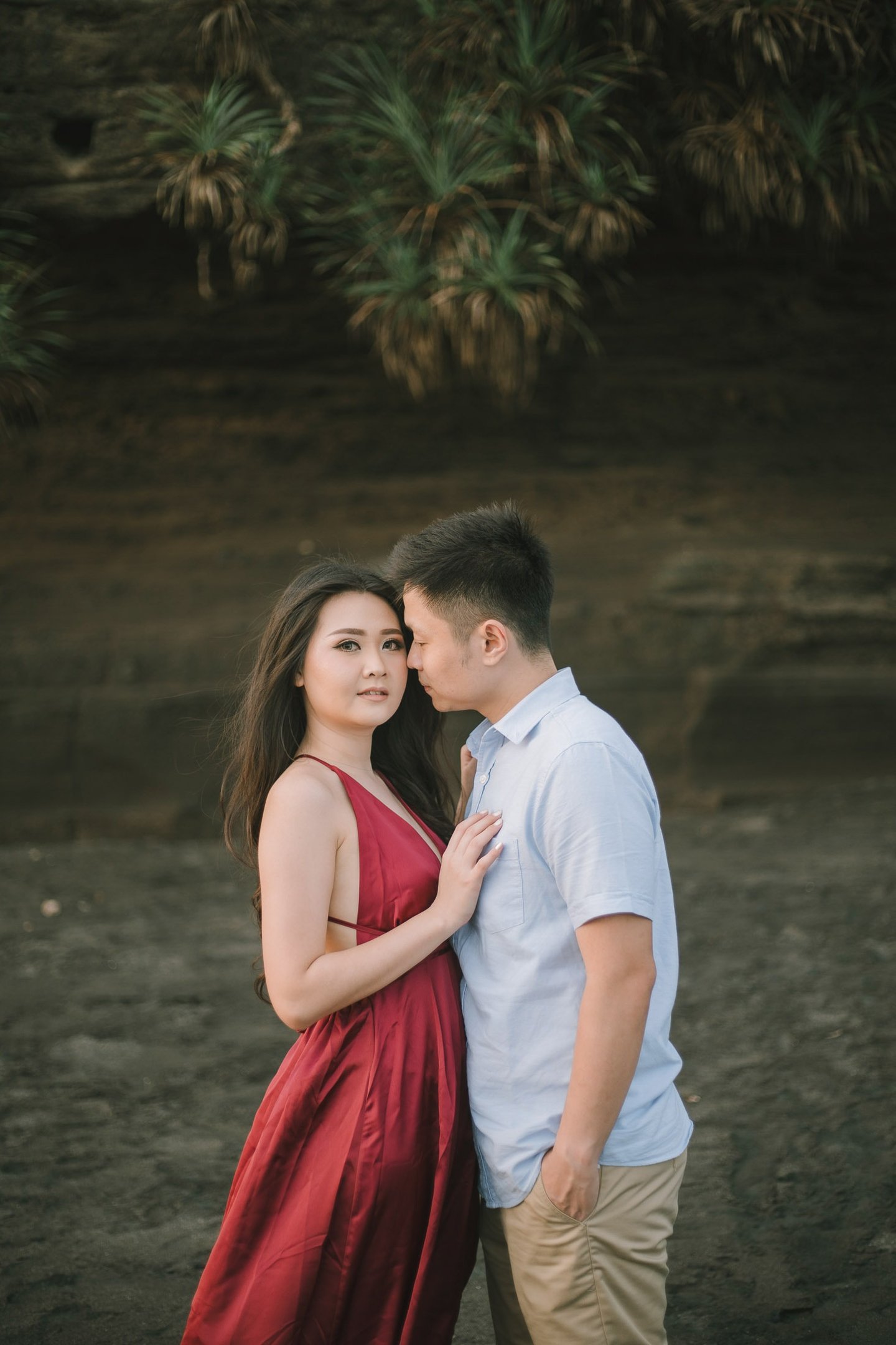 Romantic couple portrait under the cliff at Pantai Nyanyi Bali during sunset.