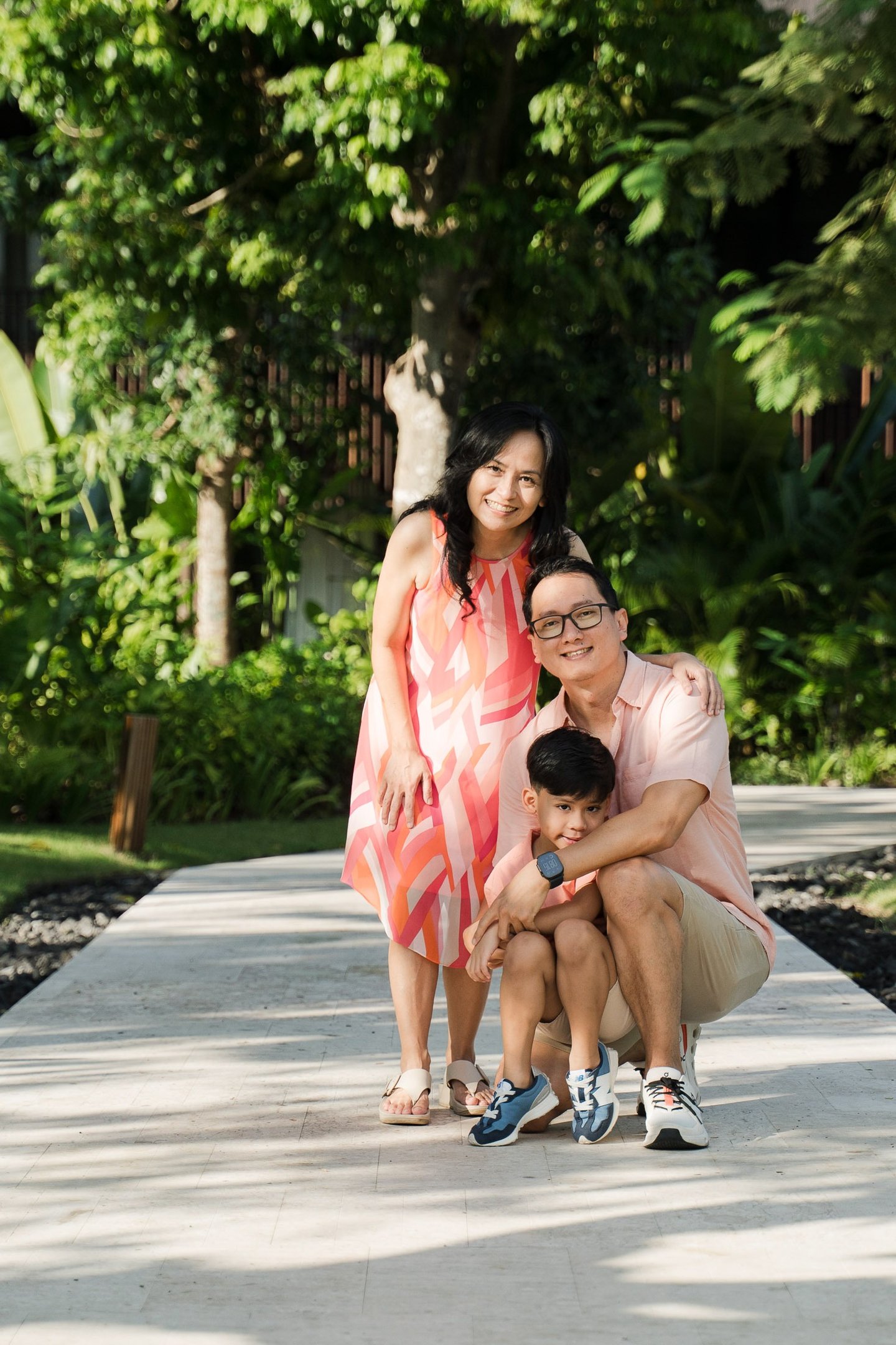 Mother father and child portrait on garden pathway at The Meru Sanur Bali family photography session