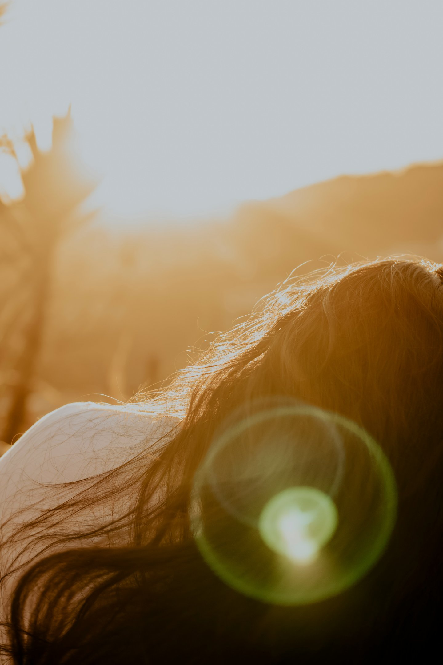woman lying in nature with soft sunshine eliciting feelings of emotional balance