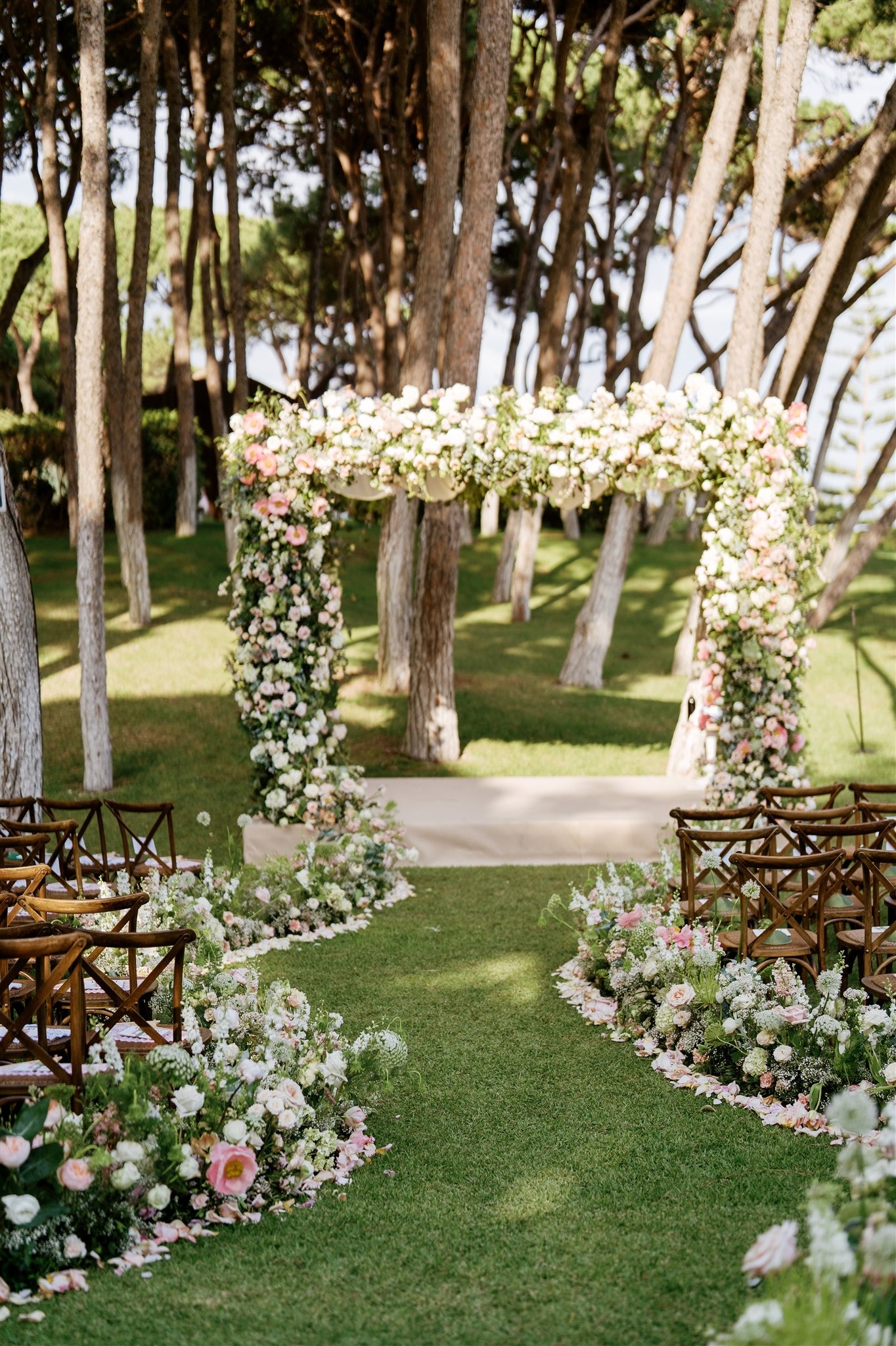 Wedding ceremony setup at Villa El Rincon with floral arch and garden seating