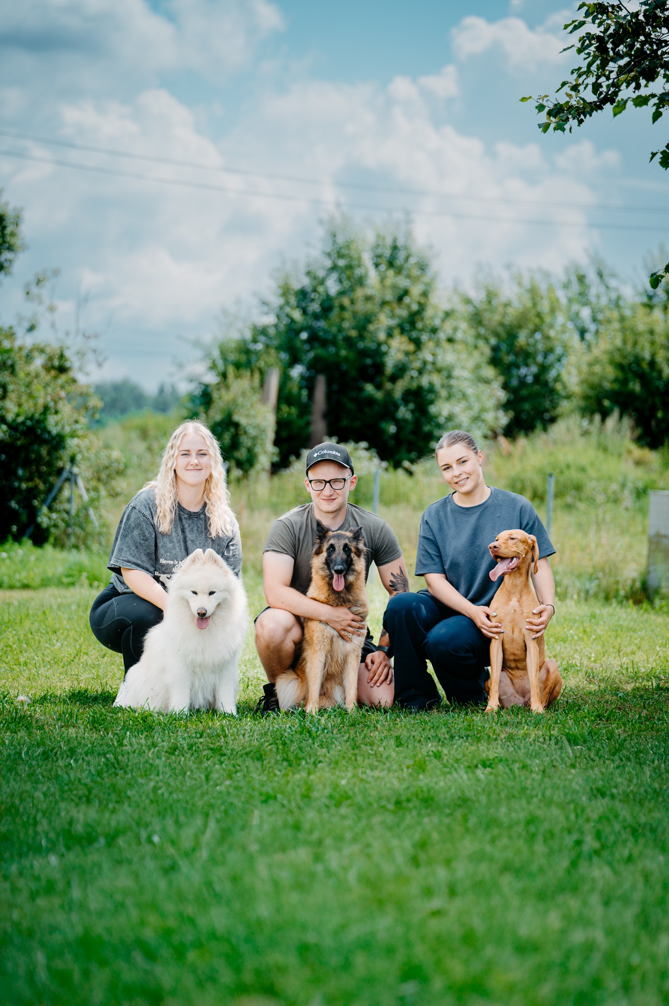 treneris su asistentėmis ir savo šunimis