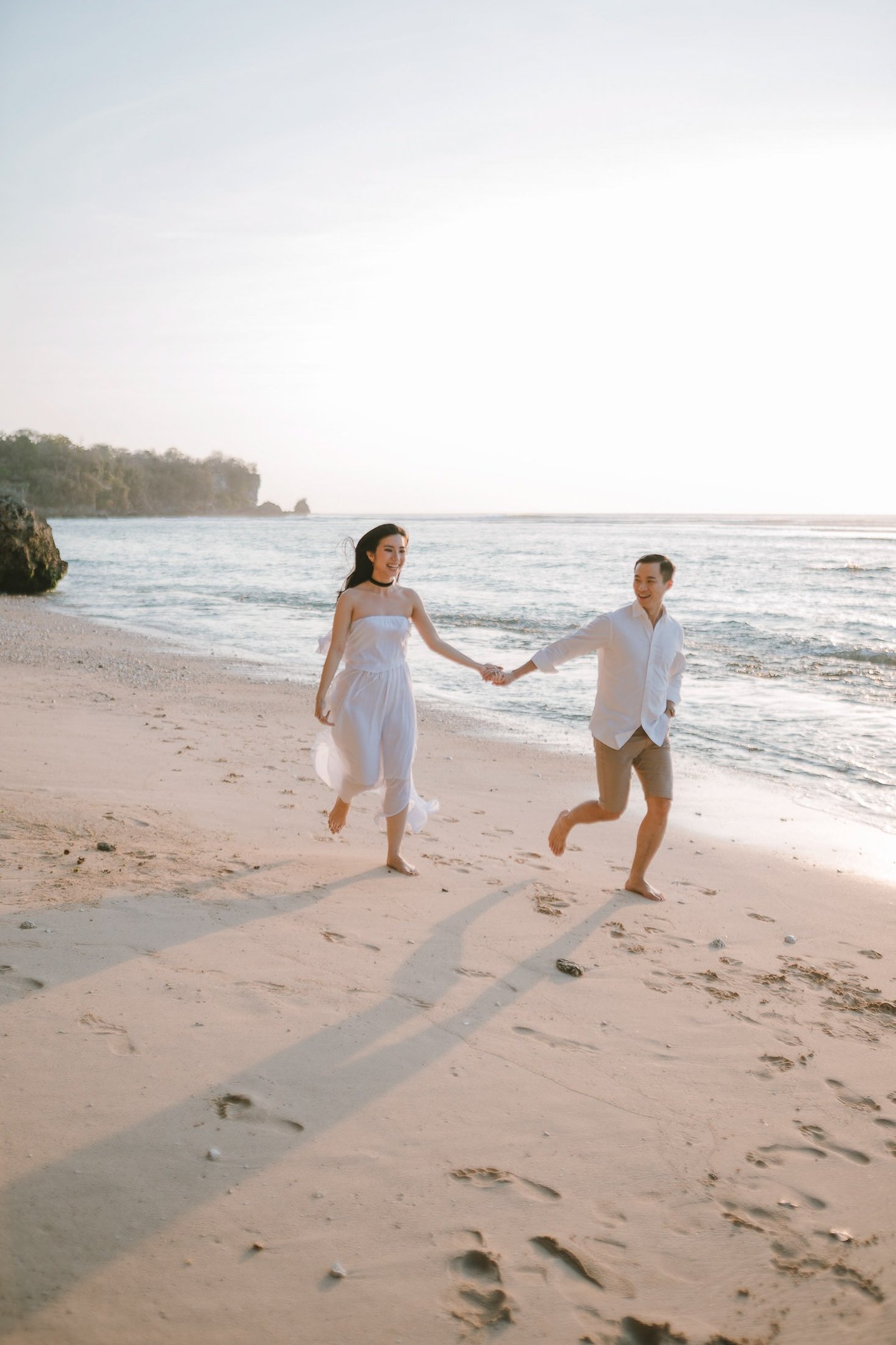 Couple running on the beach after a proposal photography session at Anantara Uluwatu Bali Resort.