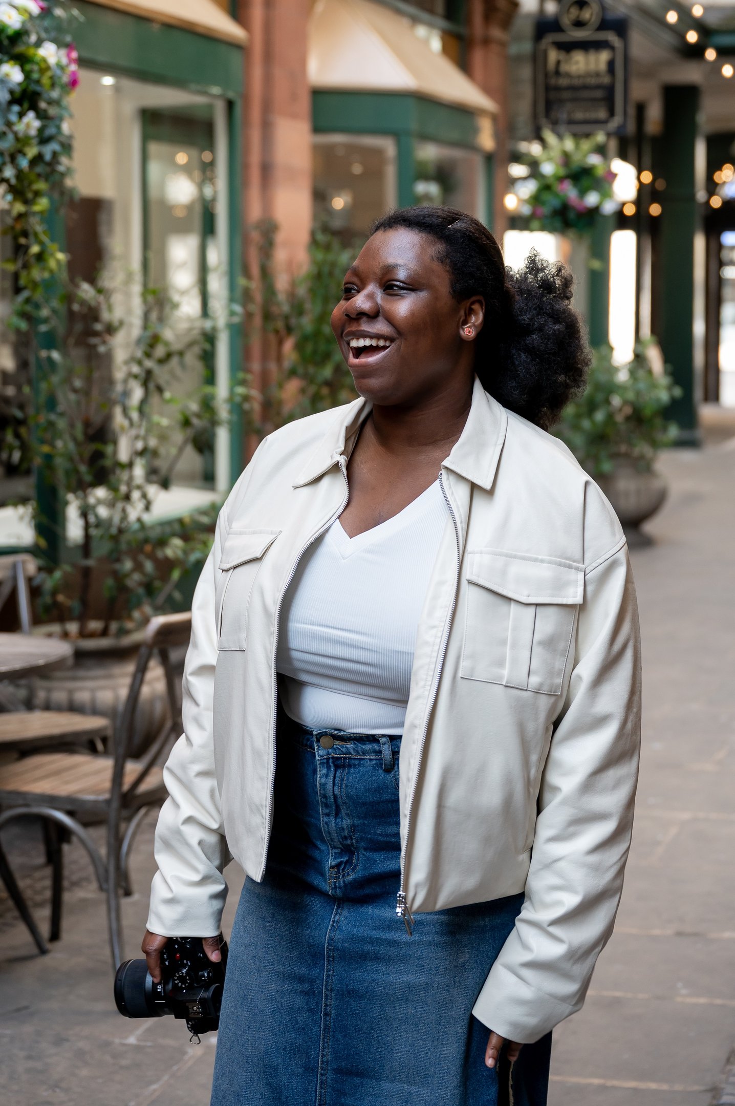 a black woman in a white jacket and jeans portrait photography