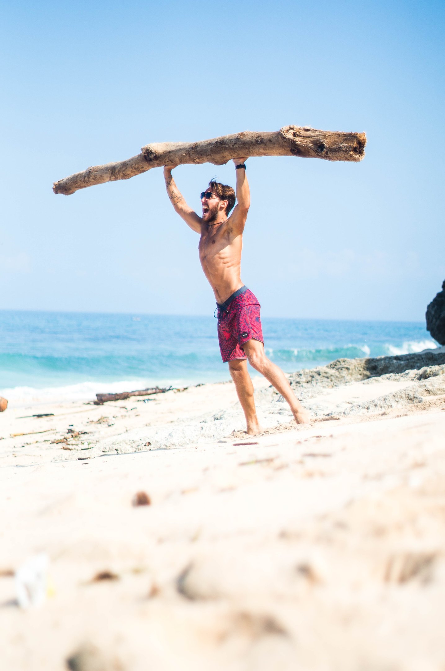 a strong man lifting a large heavy piece of wood in his hands