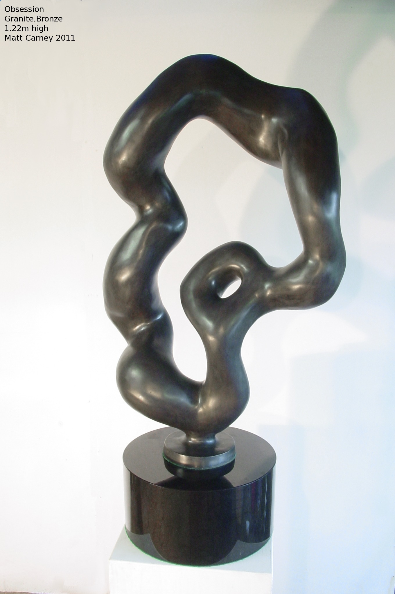 an abstract bronze sculpture on a black granite base
