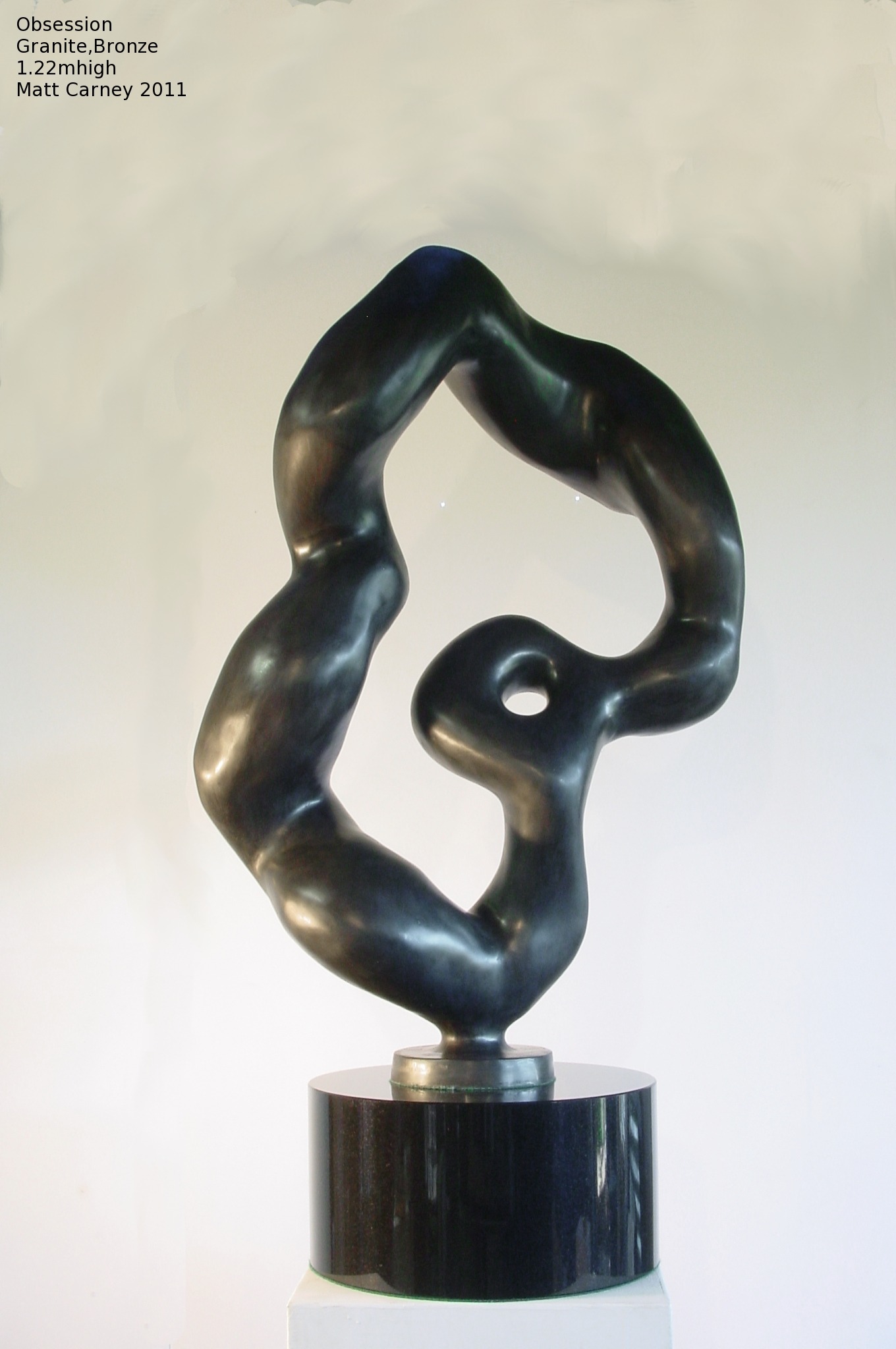 an abstract bronze sculpture on a black granite base