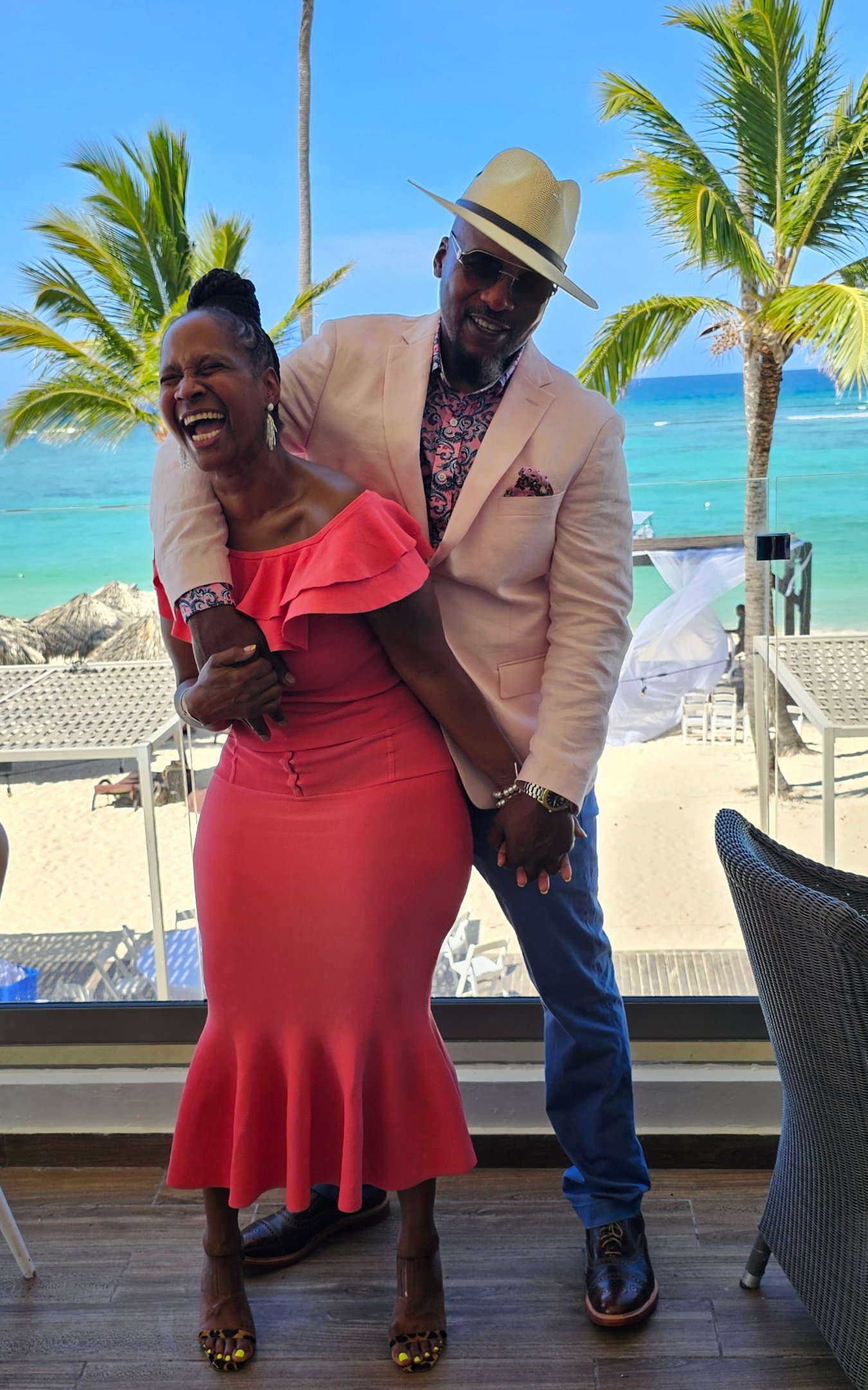 a man and woman standing in front of a window