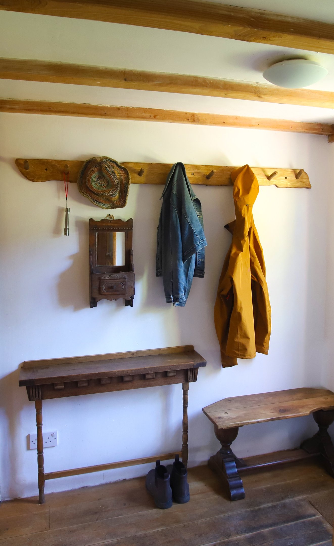 Holiday rental coat rack with jackets, a hat and a pair of boots