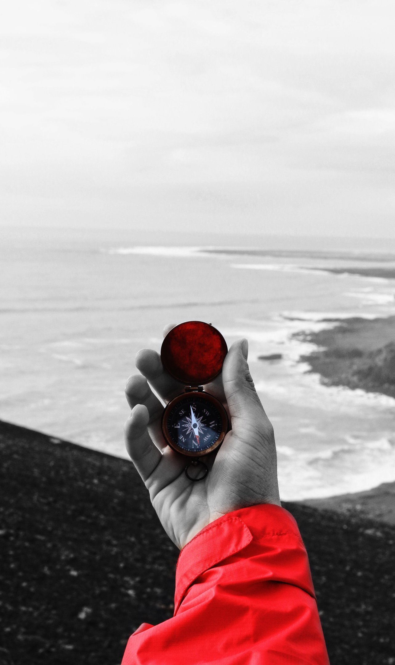 a person holding a compass on a beach