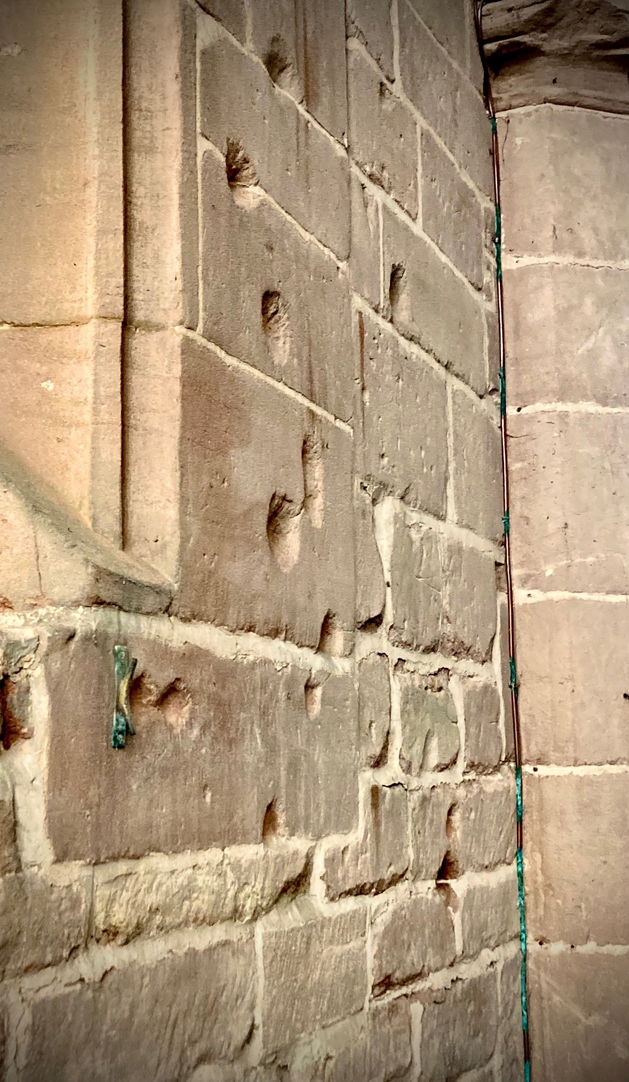 photograph showing musket damage to a stone wall. 