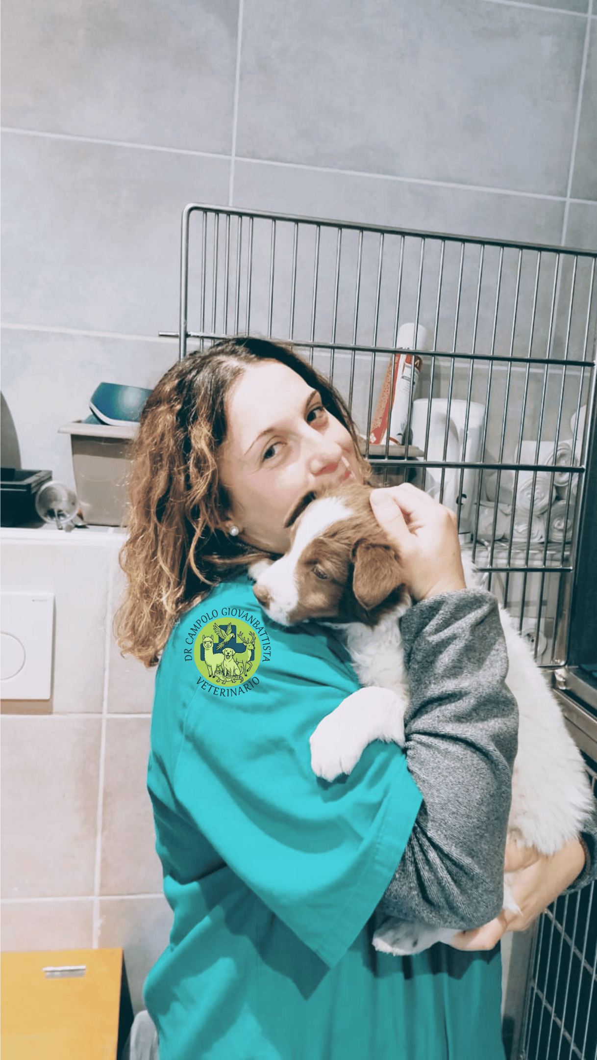 Tecnico veterinario Eleonora che abbraccia un cagnolino dentro una struttura veterinaria