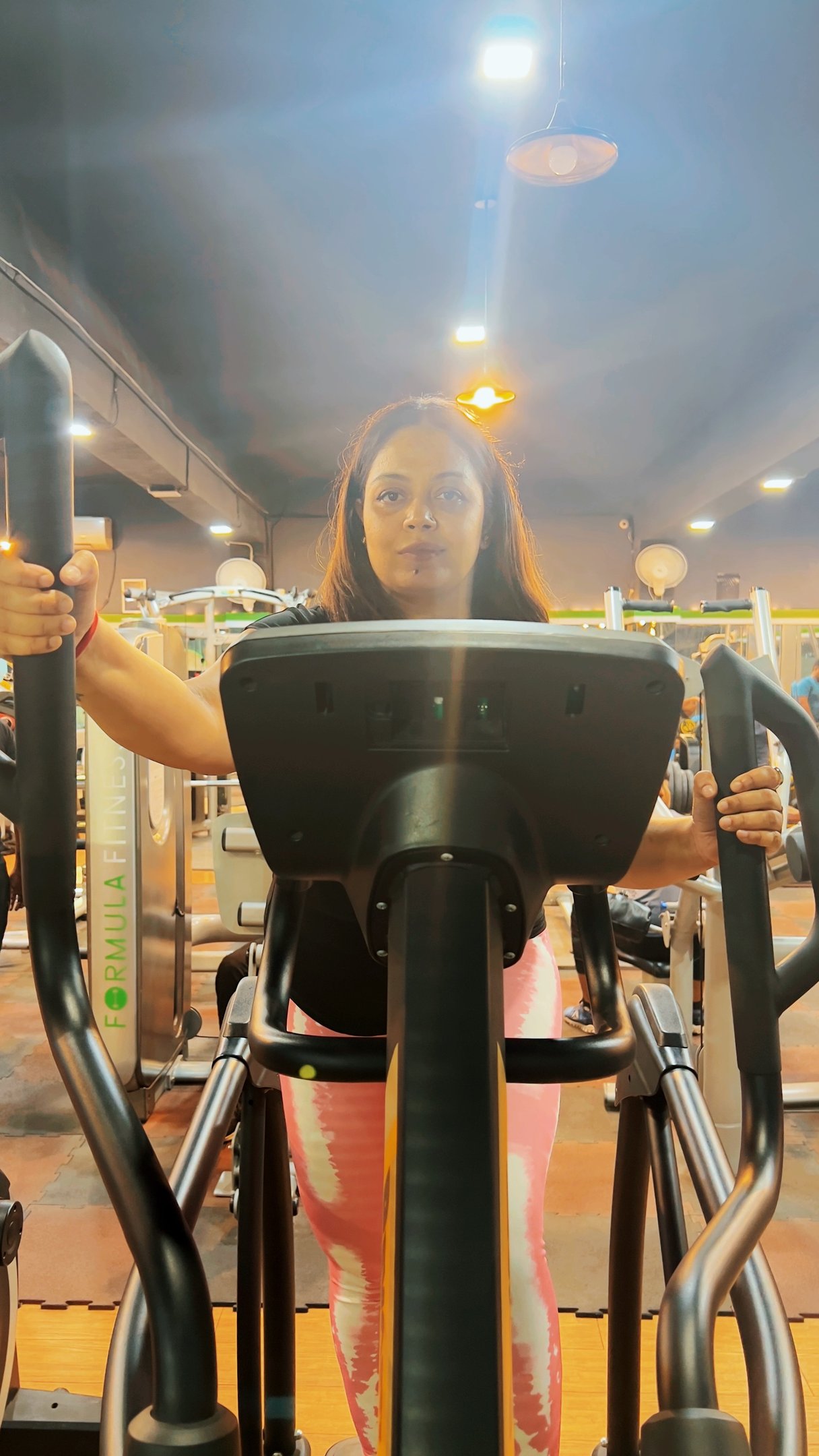 a woman is standing on a stationary stationary stationary stationary exercise machine