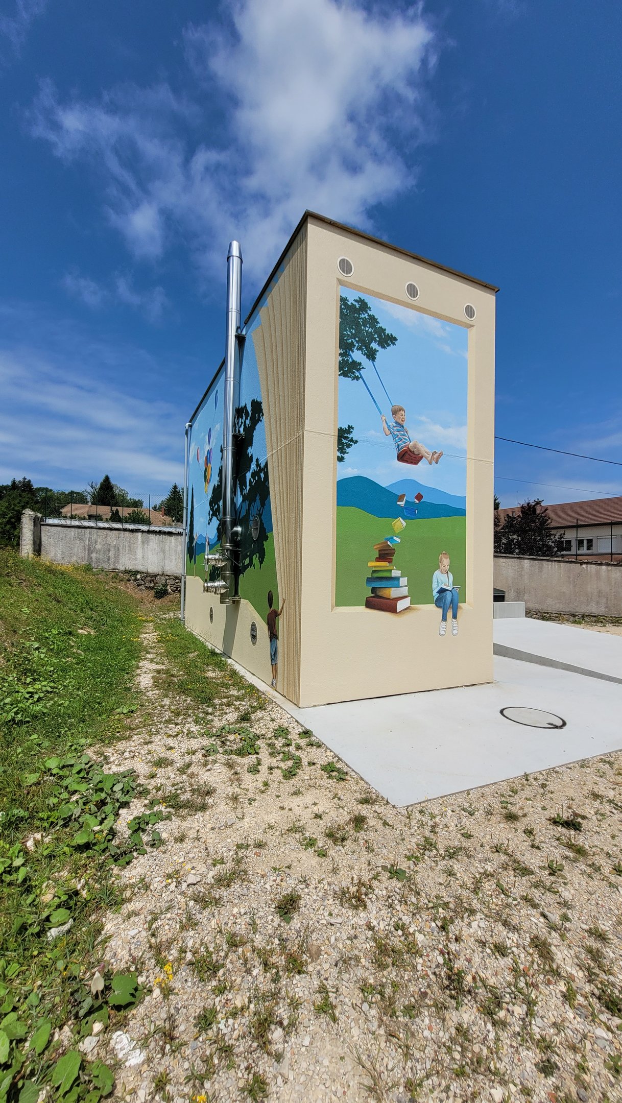 Fresques peintes sur façades. Des pages de livre, des enfants, un paysage simplifié.