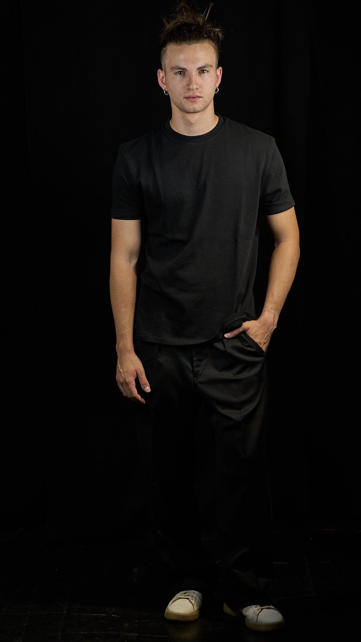 a man in a black shirt and white sneakers