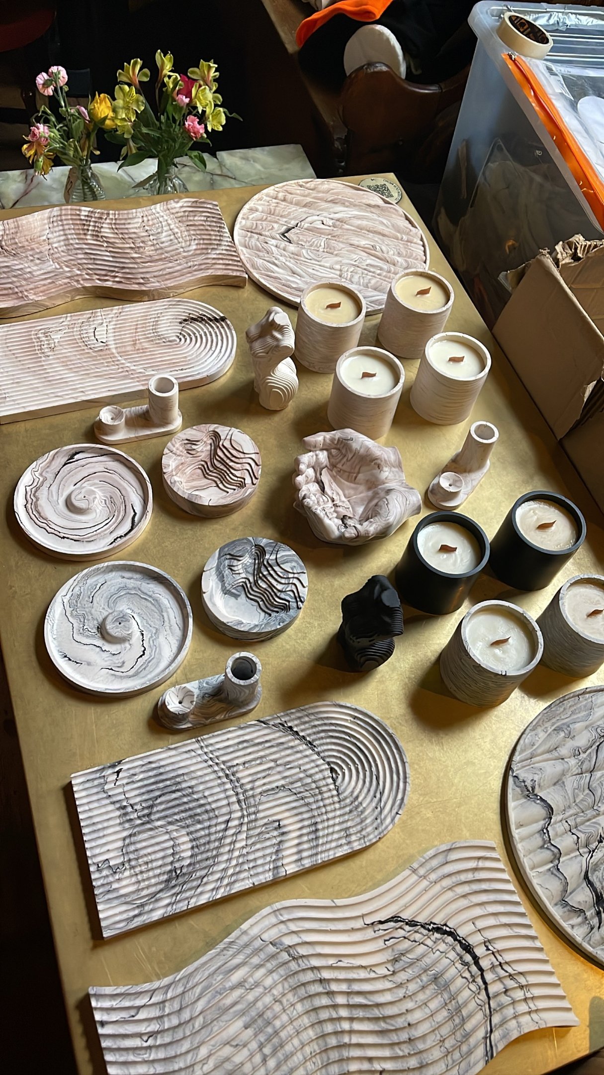 a table with a lot of different types of jesmonite pieces and candles