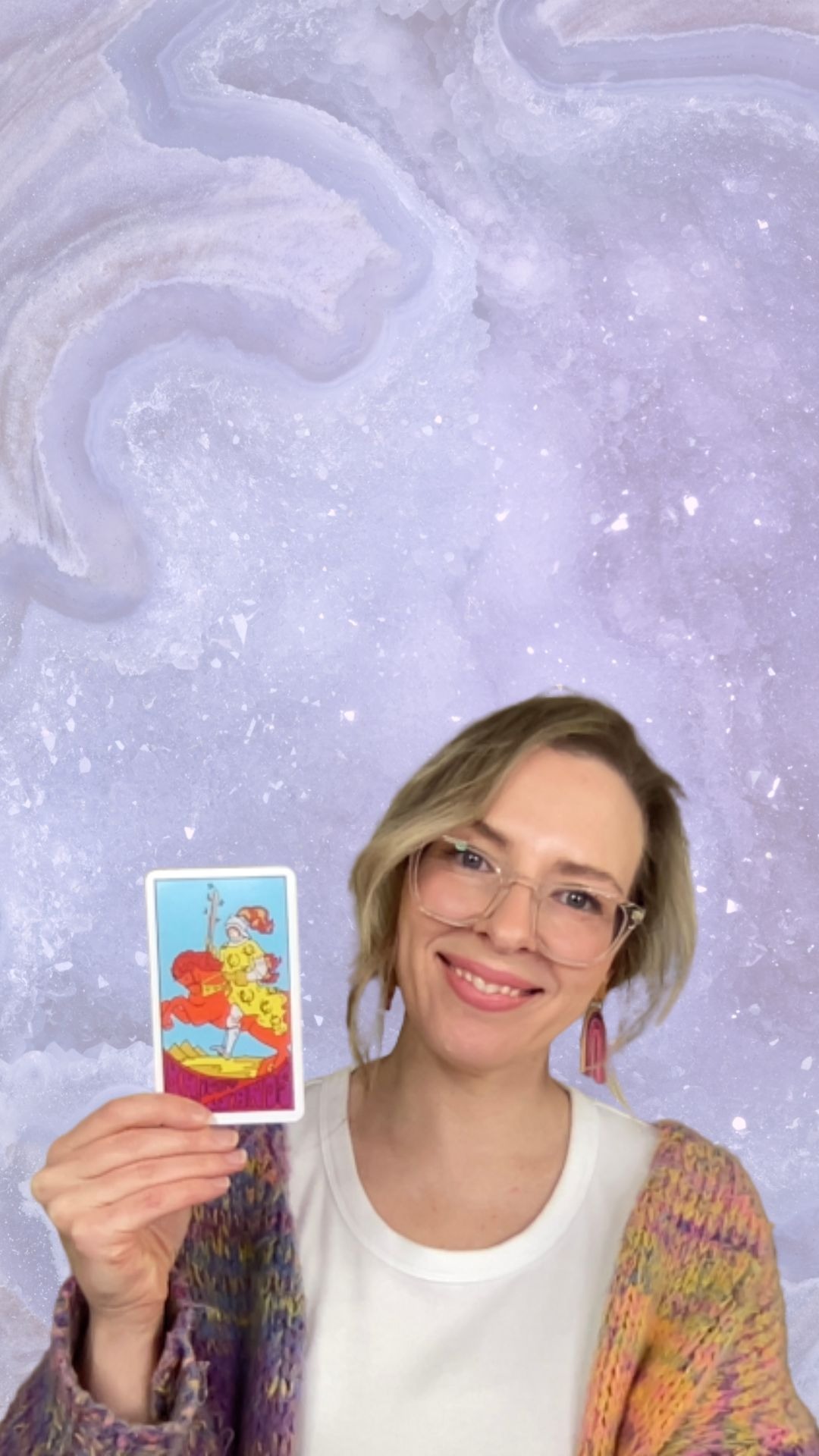 Natalie Grace, Founder of Crystal Aura Tarot, holding the Knight of Wands tarot card