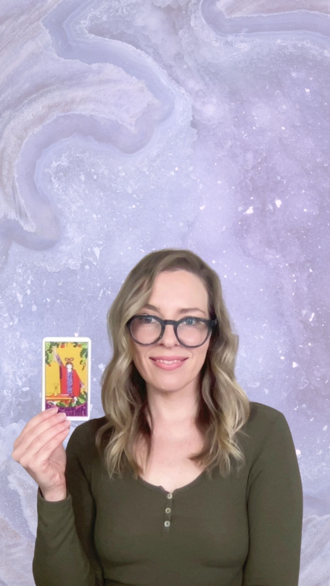 Natalie holding The Magician tarot card for a Crystal Aura Tarot reading.