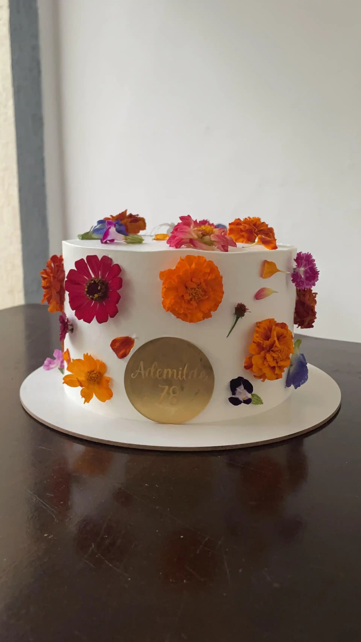 Bolo decorado com flores coloridas, ideal para festas e celebrações, destacando o design delicado e 