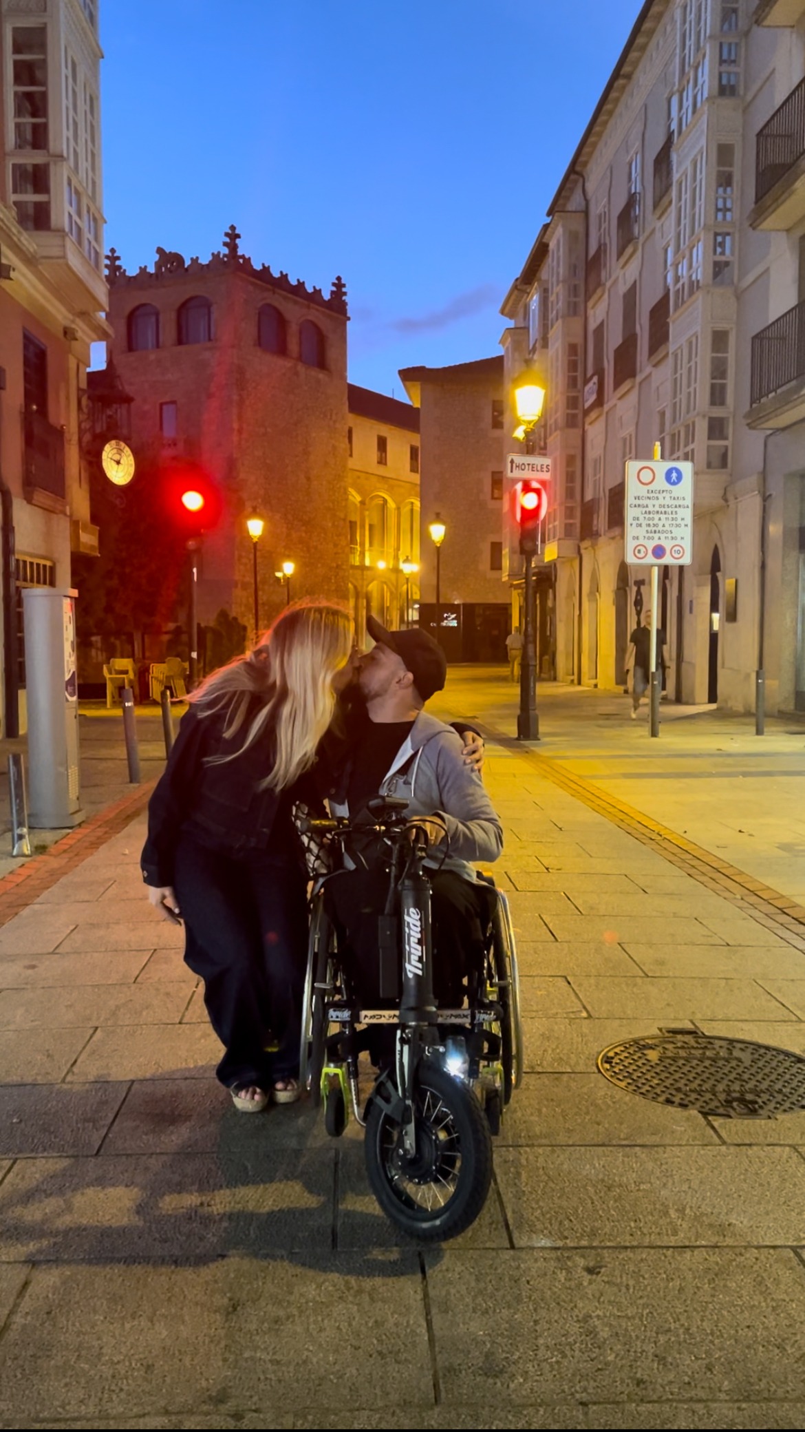 a man and woman kissing on a city street
