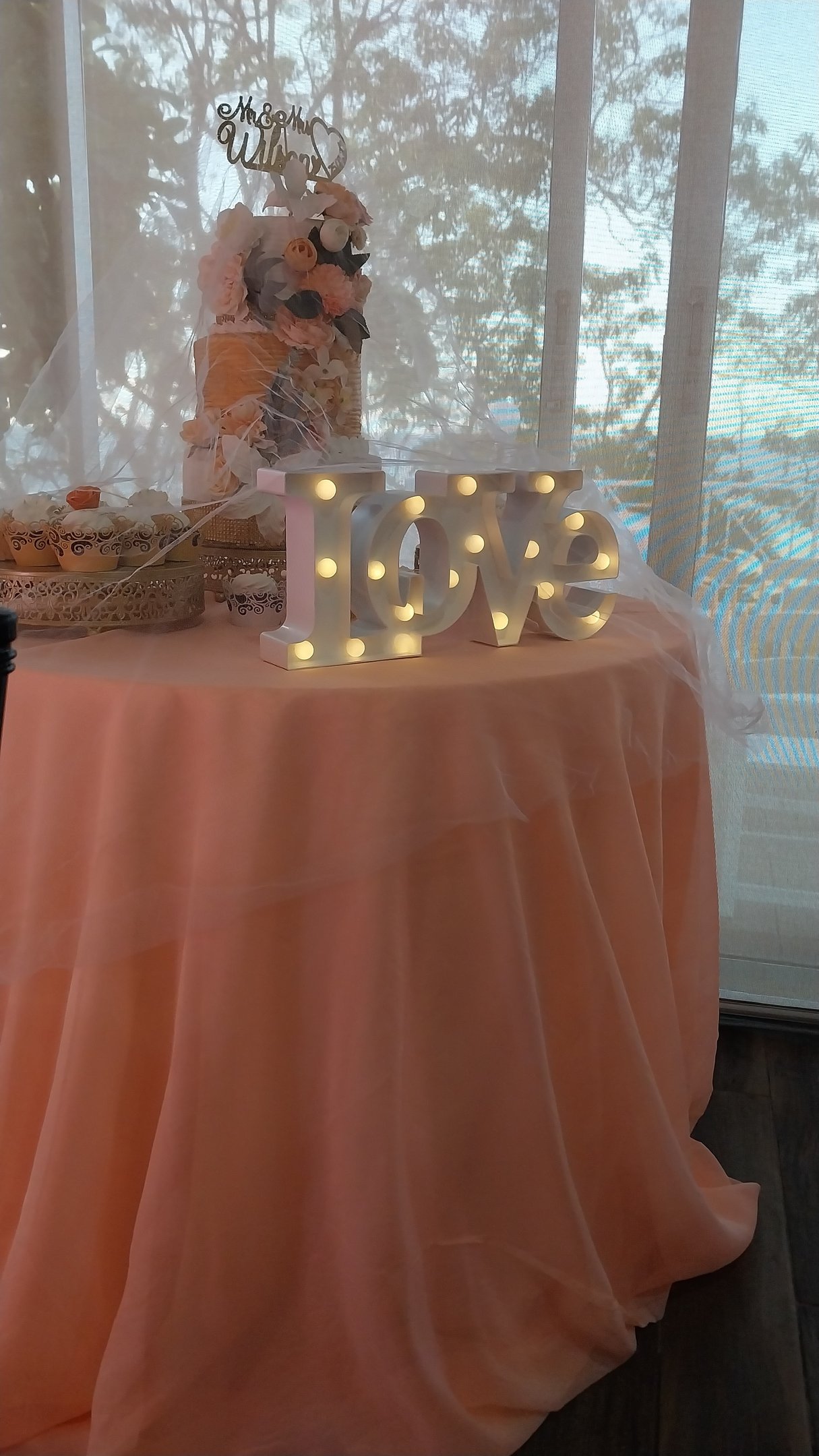 a table with a table cloth and a cake and a love sign