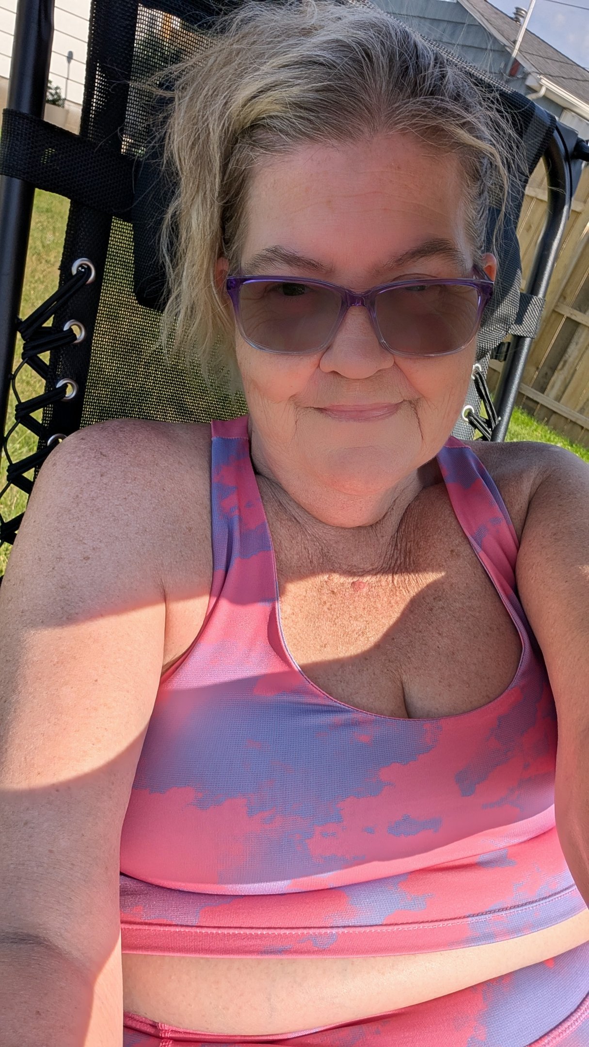 woman lounging in the sun, in her backyard