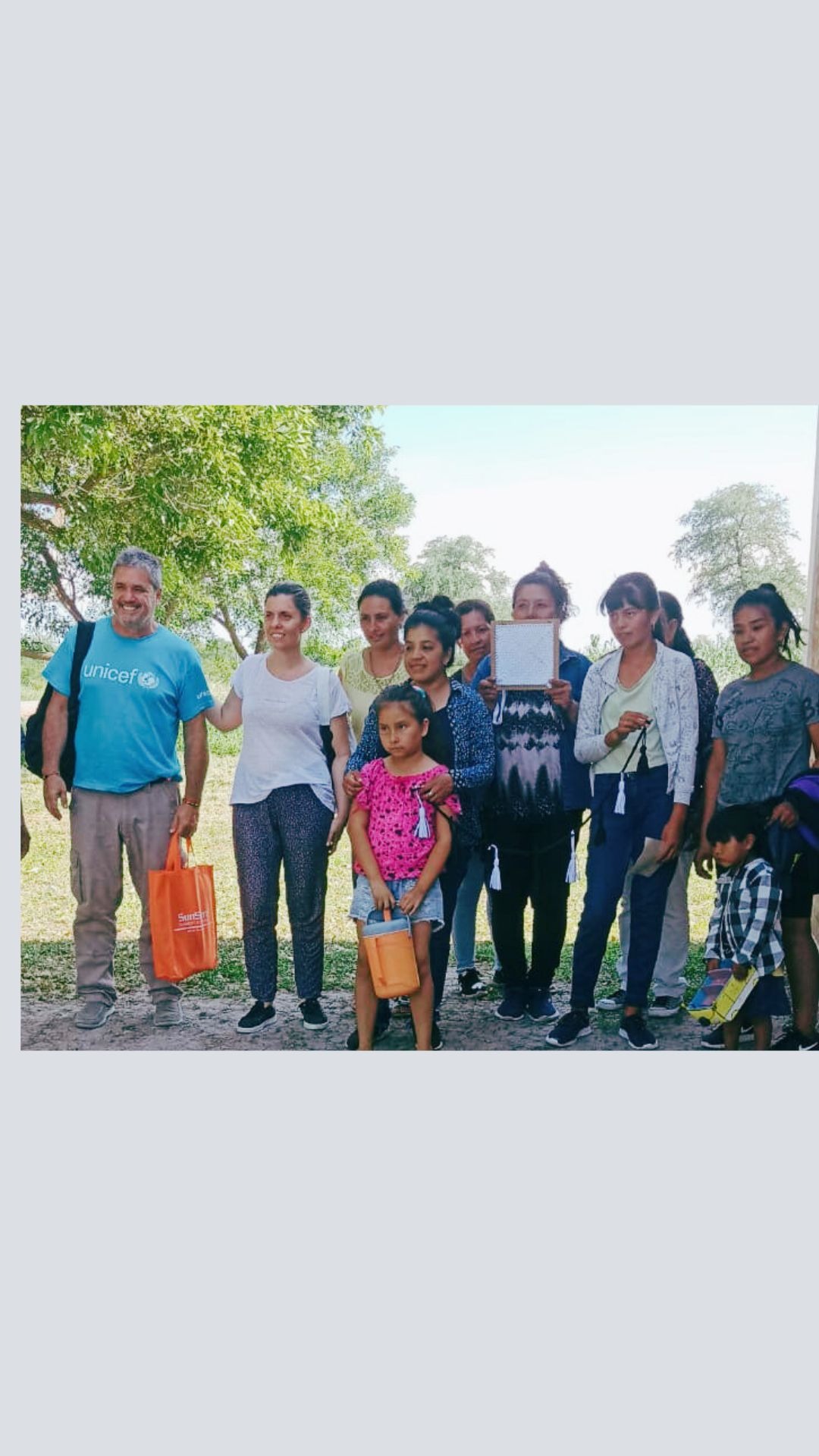 A UNICEF volunteer with a group of women and children in a community outreach program.