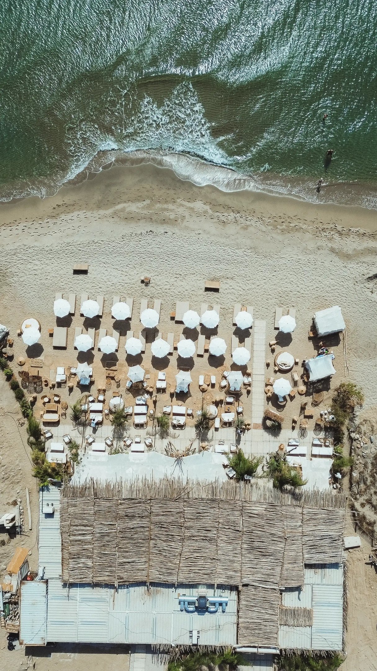 ue aérienne de la plage privée Playa Amor à Leucate, avec lits et transats face à la Méditerranée