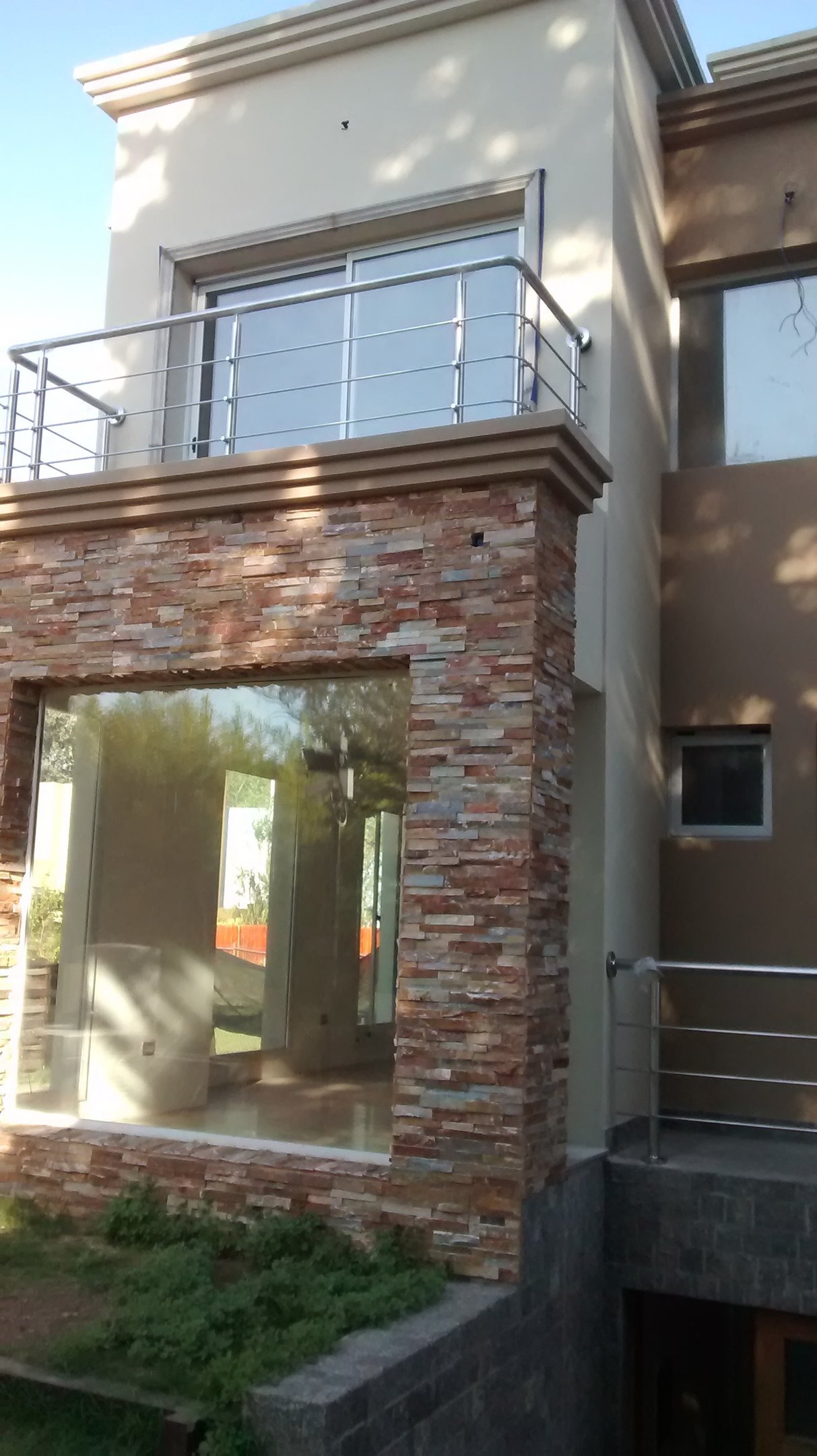 balcón de una casa con baranda en acero inoxidable