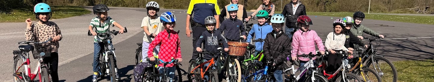 Gruppe von Kindern mit Fahrrädern und Helmen beim Fahrradtraining von Niederkrüchten hilft