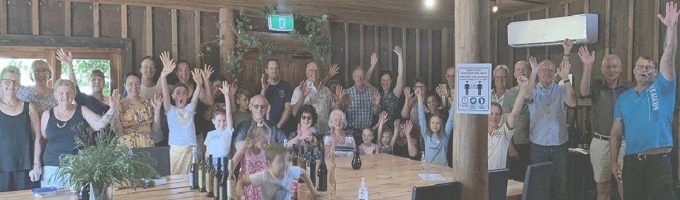 People gathered in a barn and waving at the camera