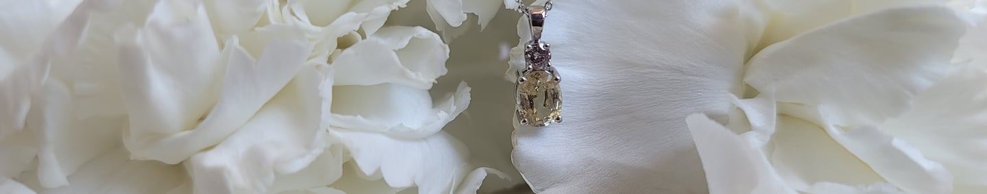 Chael jewelry - yellow sapphire and pink diamond necklace hanging on white flowers