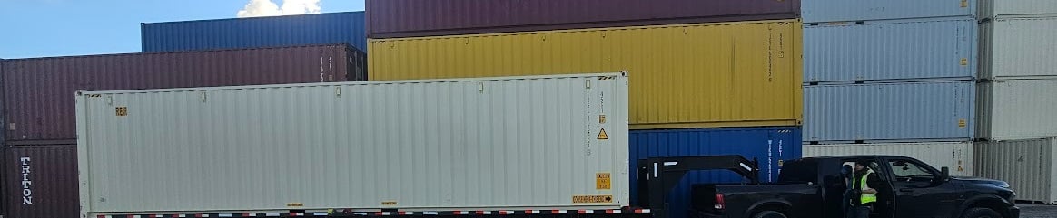 A black Ram 3500 pulling a 40ft trailer with a new 40ft tan chipping container