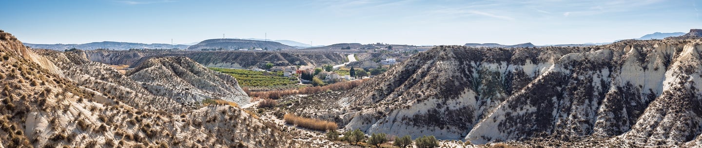 View of the hamlet of Baños de Mula and its surroundings from the stone bridge that crosses the Pere