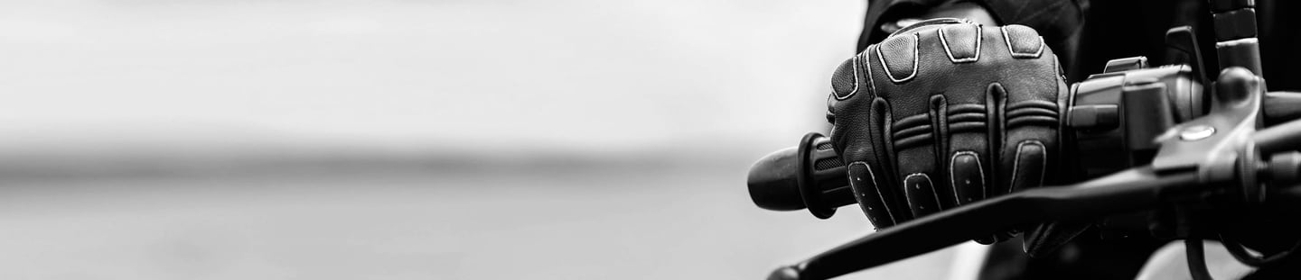 Close up picture of the right hand side of a motorcycle handlebar that is holding the throttle