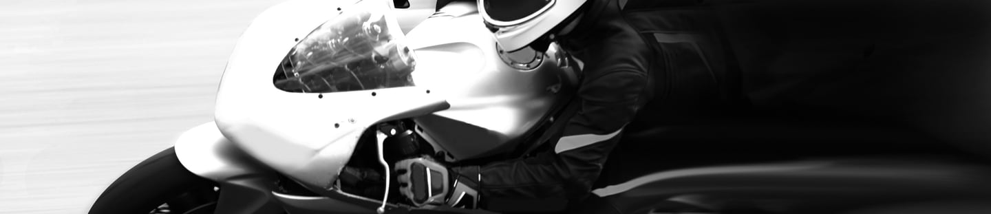 Image of a motorcyclist on a sports bike with white tank and front fairing moving at speed from rig