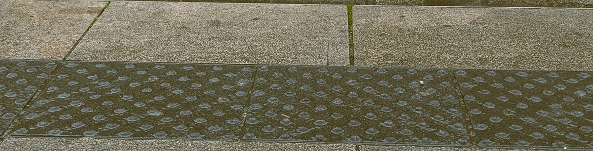 Vue de mes pieds dans mes chaussures blanches en attendant le tramway à Montpellier