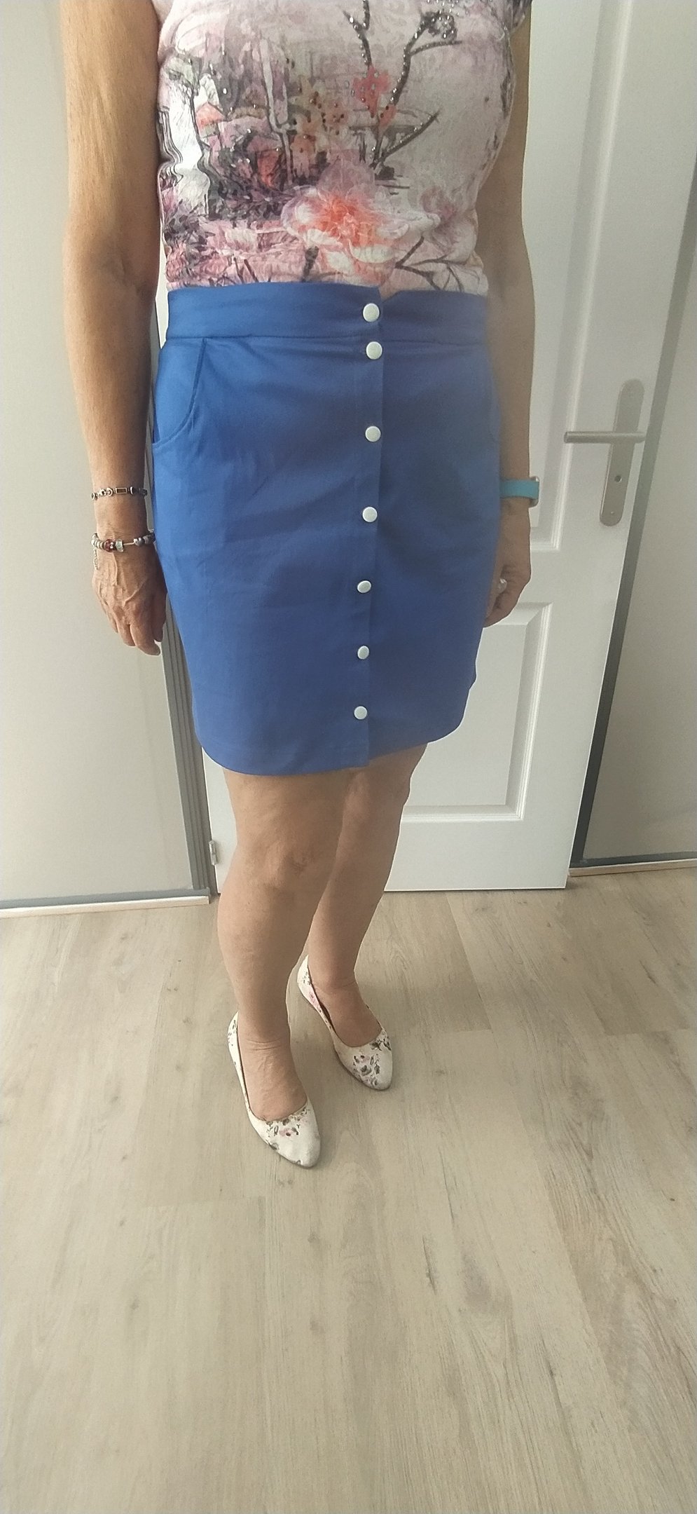 a woman in a floral top and skirt