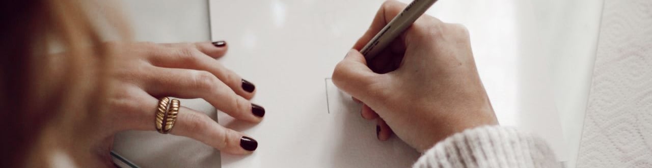 a woman is writing on a piece of paper