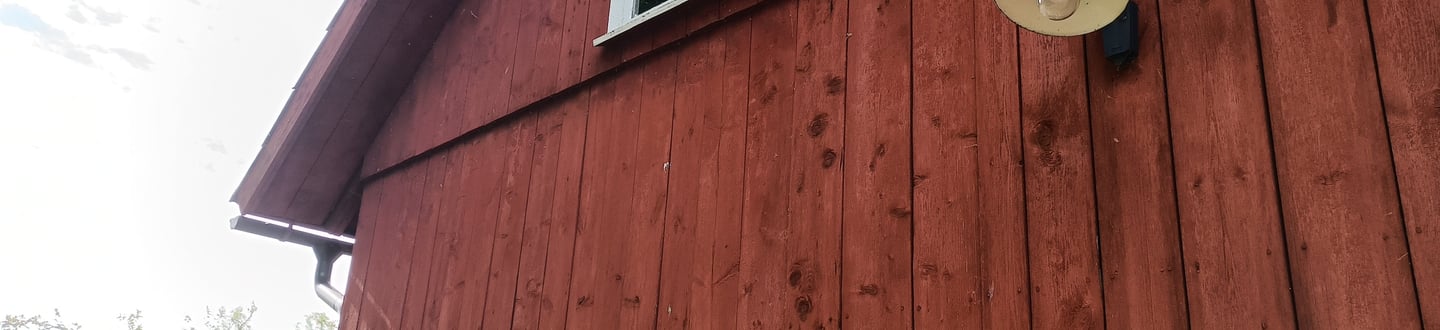 Historic red barn painted with iron oxide and linseed oil — traditional breathable barn paint that fades instead of peeling