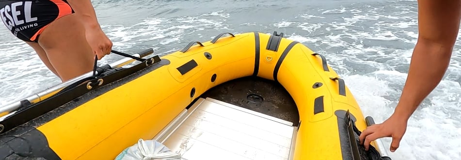 Una neumática desmontable echándose al agua en la playa