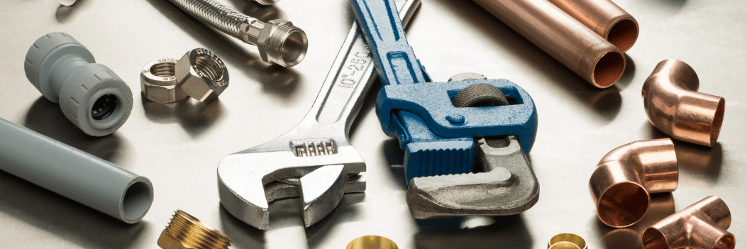 a selection of plumbing tools and pipe fittings