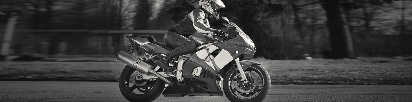 Black & White photograph of a rider riding from left to right on a sports bike
