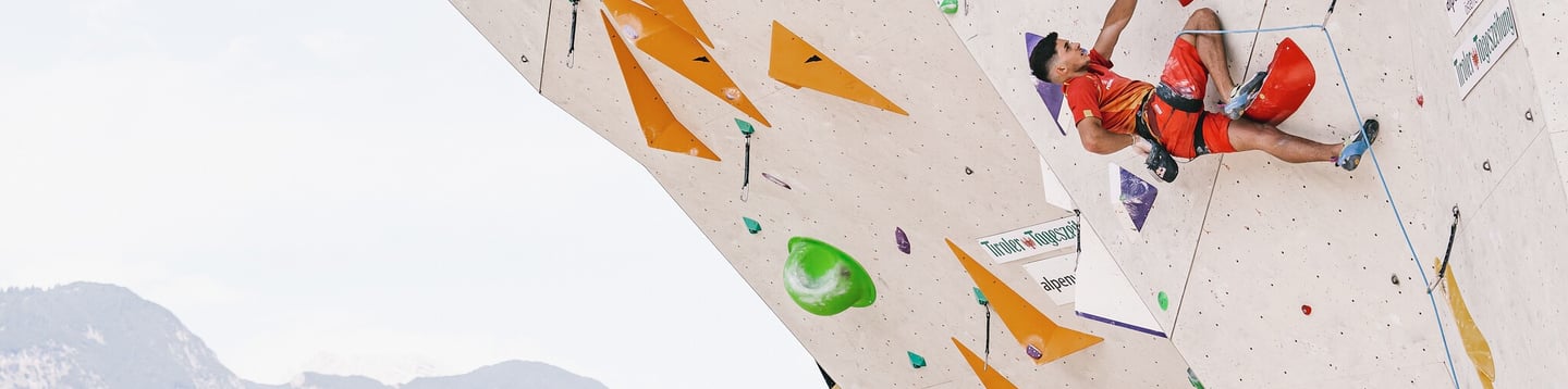 a man is lead climbing on a climbing wall