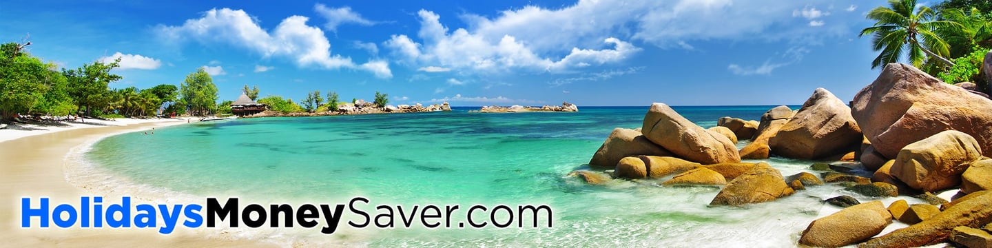 Perfect Beach with Golden Sand and Blue Sky, with Trees and Beach Huts in the Background