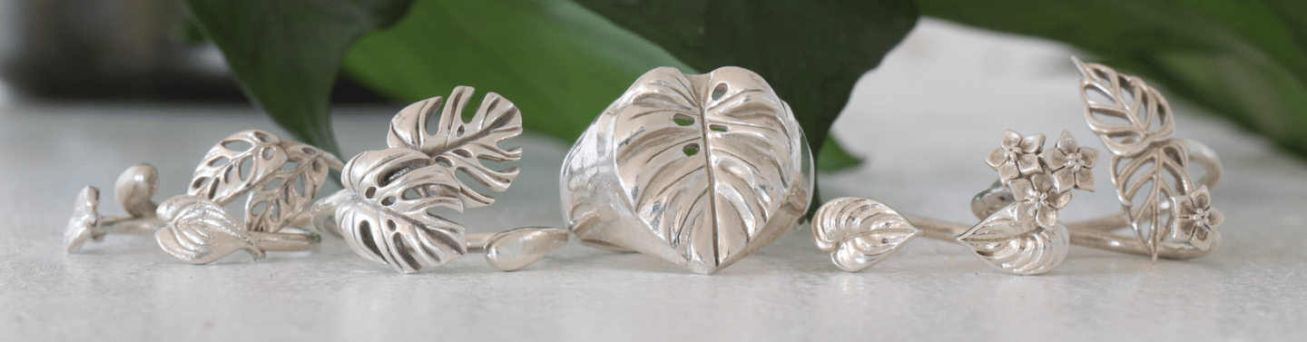 seven botanical plant rings arranged in front of a green leafy background