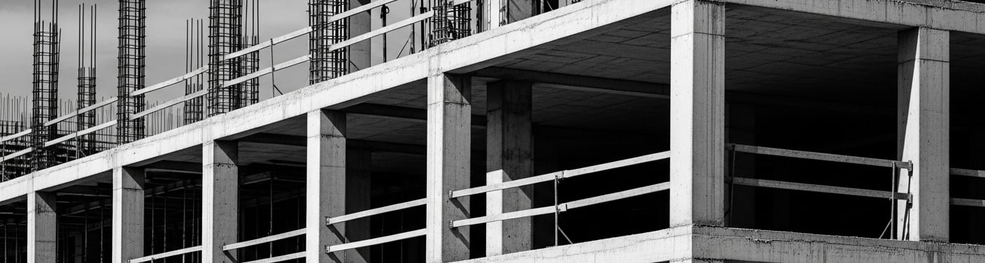 Estrutura de concreto em construção representando rigidez no investimento imobiliário